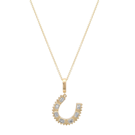 Close-up of the 14K yellow gold Emerald Cut Diamond Horseshoe Charm Pendant by Sig Ward Jewelry, showcasing emerald-cut natural diamonds and fine craftsmanship.