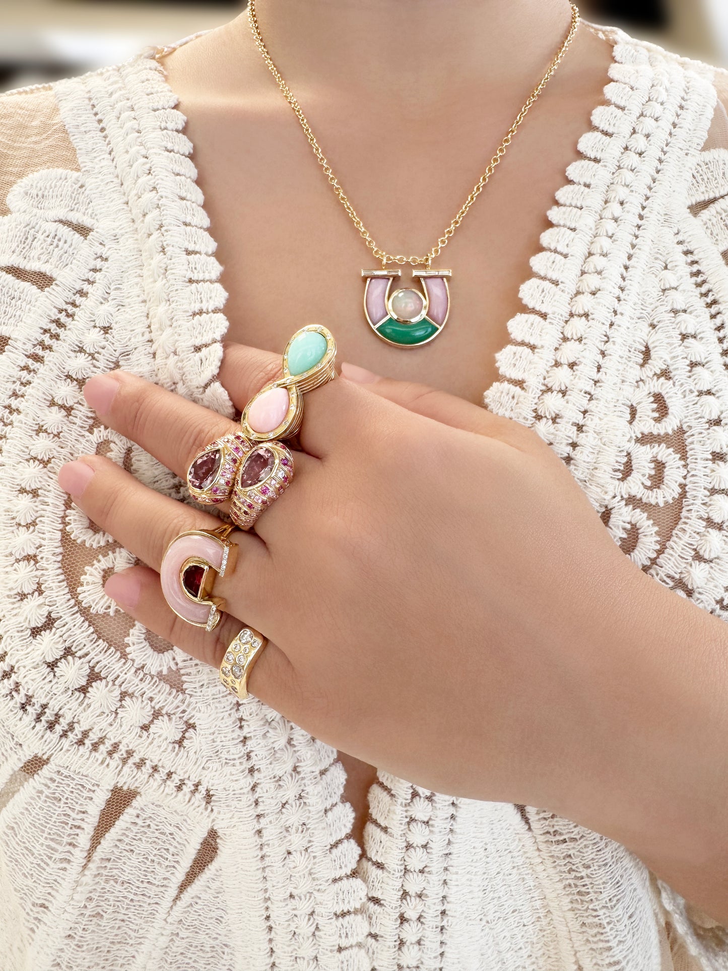 Sig Ward Jewelry Lifestyle 14K YG Garnet, Pink Opal and Diamond Horseshoe Ring featuring rich garnet and pink opal gemstones with sparkling diamond accents set in a luxurious yellow gold horseshoe design.