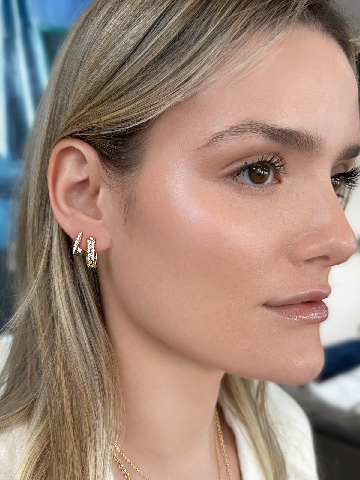 Lifestyle image featuring the 14K yellow gold Mave Scattered Diamond Huggies by Sig Ward Jewelry, showcasing natural scattered diamonds in a modern, elegant huggie hoop earring design.