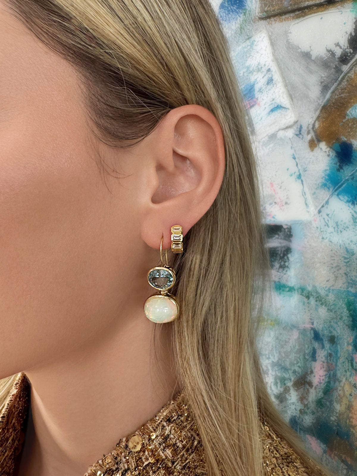 Lifestyle image featuring the 14K yellow gold Opal and Aquamarine Duo Earrings and 14K yellow gold Belle Emerald Cut Diamond Huggies by Sig Ward Jewelry, showcasing natural opal, aquamarine, and emerald-cut diamonds in elegant fine jewelry designs.