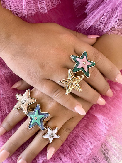 Stack of Sig Ward Jewelry 14K gold and diamond Star Power rings featuring inlaid malachite, pink opal, turquoise, and white mother of pearl gemstones on a hand.