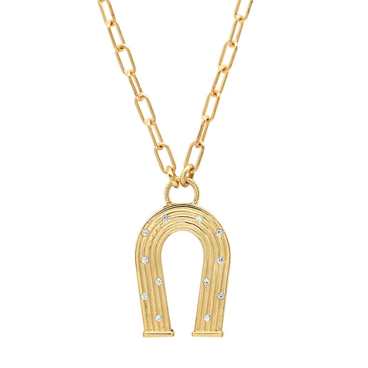 Sig Ward Jewelry 14K yellow gold mini horseshoe necklace featuring reeded gold detailing and diamond accents, a luxury fine jewelry piece with an elegant design symbolizing luck, protection, and timeless beauty.